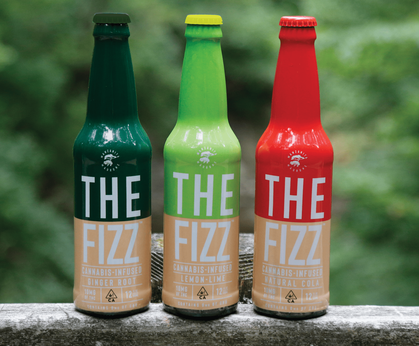Three bottles on a ledge. Each on a different kind of a product called The Fizz, a cannabis infused beverage. Ginger Root, Lemon-Lime and Natural Cola flavor